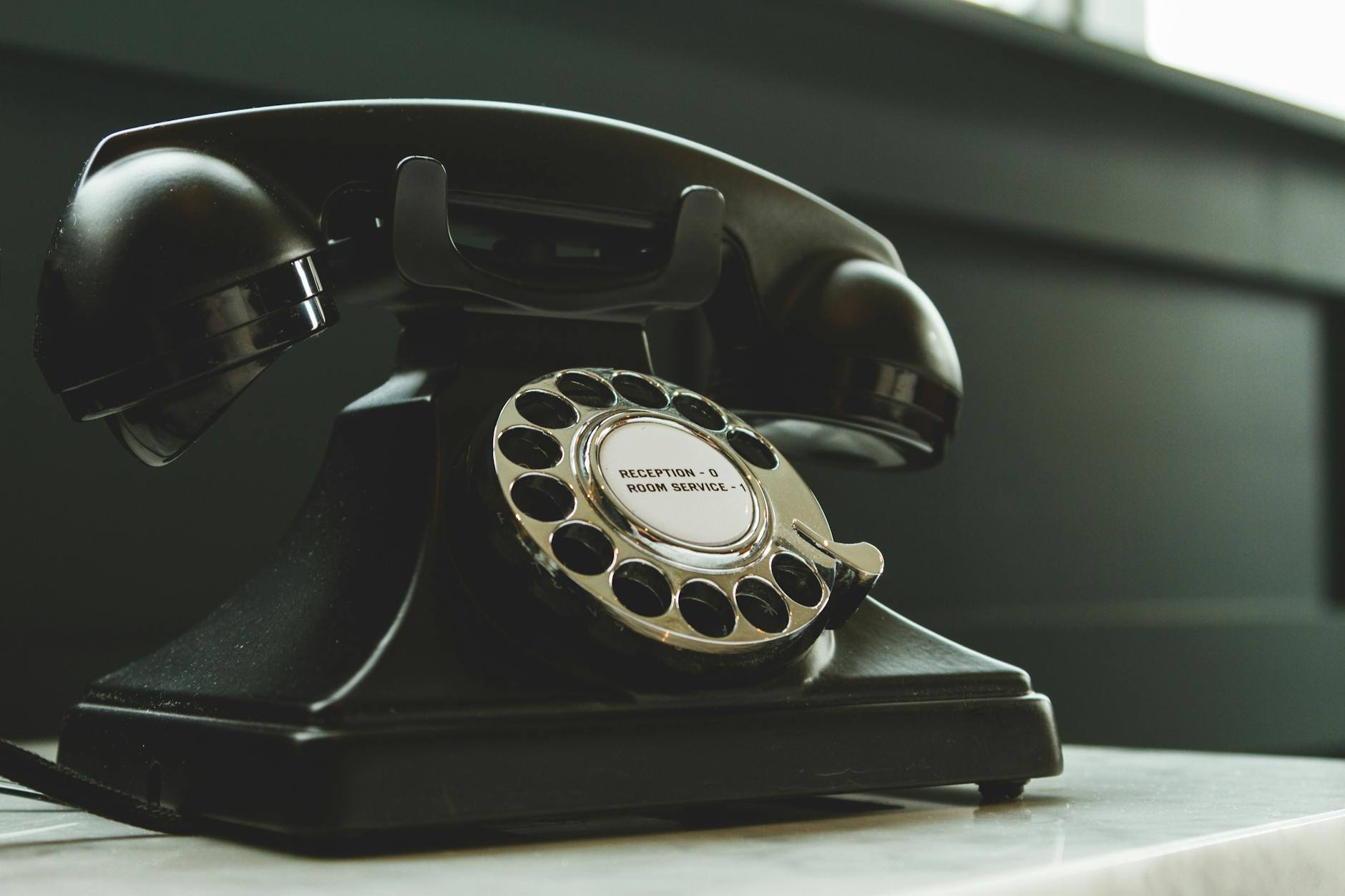 black rotary telephone on white surface. EJY Medical Writing